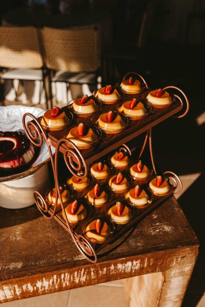 A sunlit tray showcasing delicious caramel puddings topped with strawberries, perfect for dessert lovers.